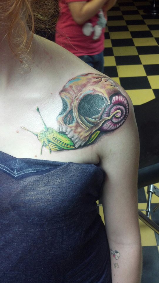 Colored Skull Shell On Snail Back Tattoo On Left Upper Shoulder