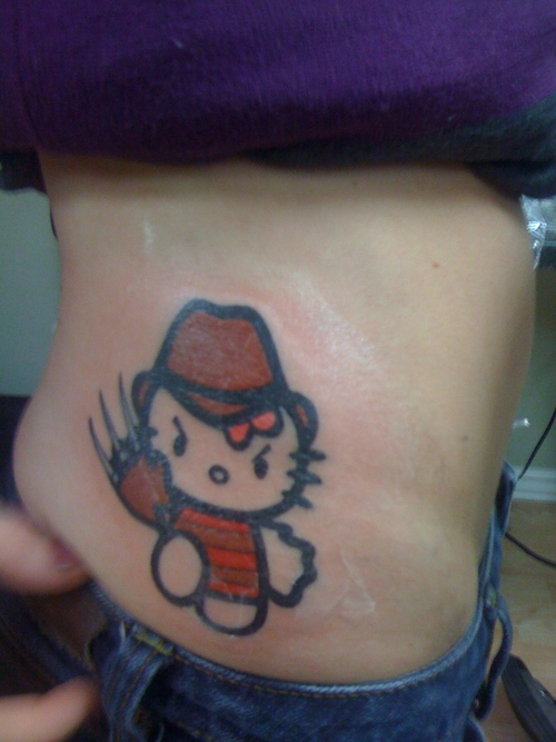 Cute Hello Kity In Freddy Krueger Style Tattoo On Side Rib