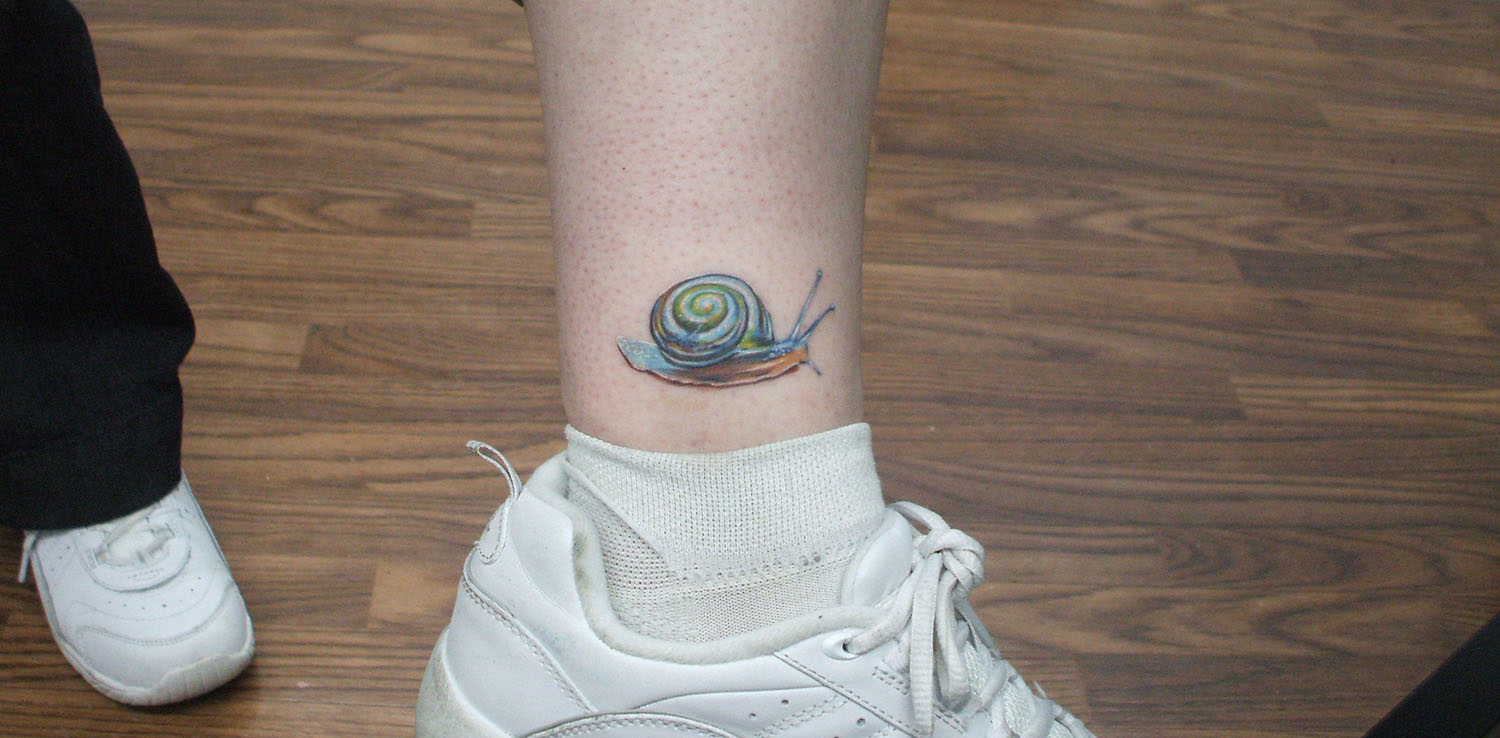 Cute Tiny Snail Colored Tattoo On Left Ankle