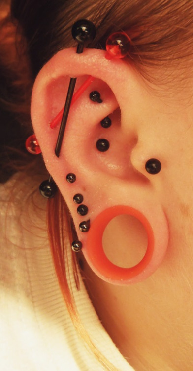 Double Industrial Piercing With Black And Orange Barbells