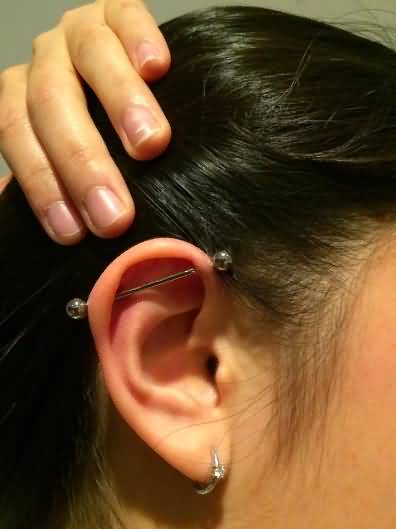 Girl Showing Her Industrial Piercing On Right Ear