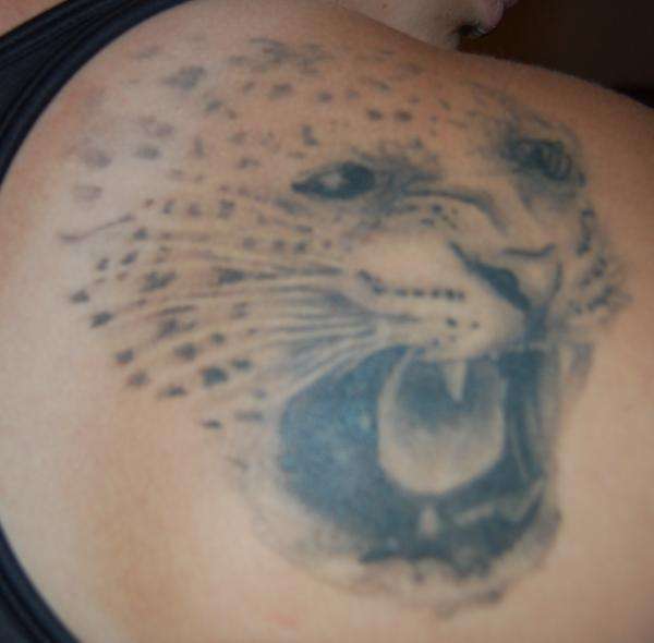 Light Colored Angry Jaguar Face Tattoo On Upper Shoulder