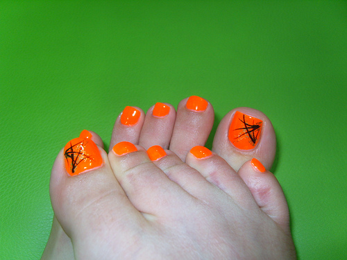 Neon Orange Toe Nails With Black Design