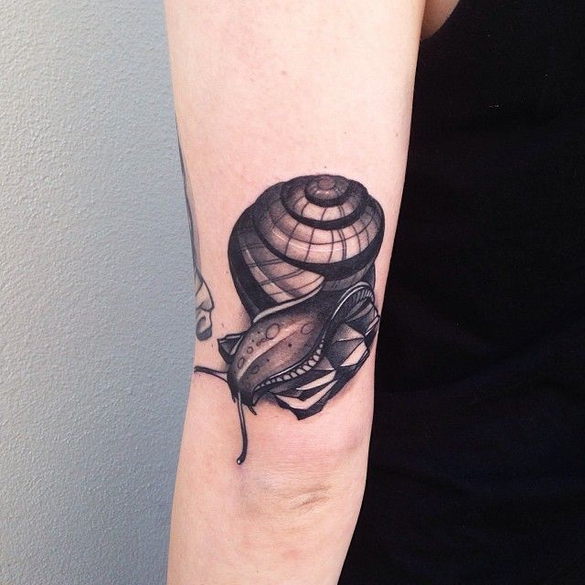Nice Dark Grey Snail Tattoo On Triceps By Pari Corbitt