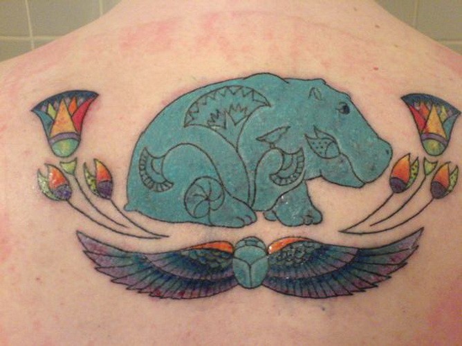 Nice Egyptian Hippo With Flowers And Wings Tattoo On Upper Back