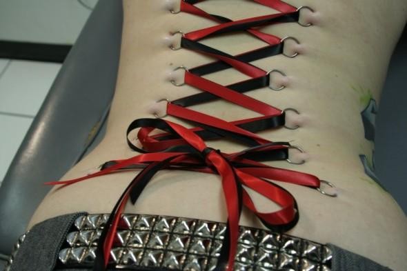 Red And Black Corset Piercing On Back Body