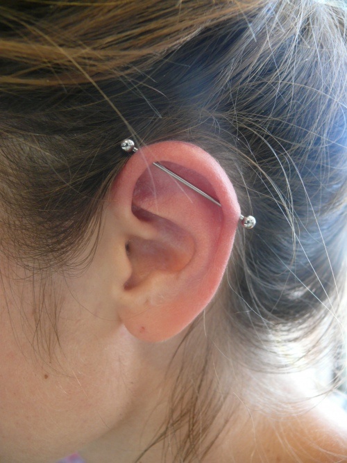 Silver Barbell Industrial Piercing On Girl Left Ear