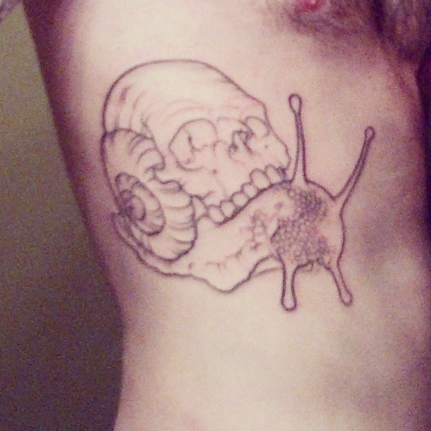 Simple Grey Skull On Snail Back Tattoo On Side Rib