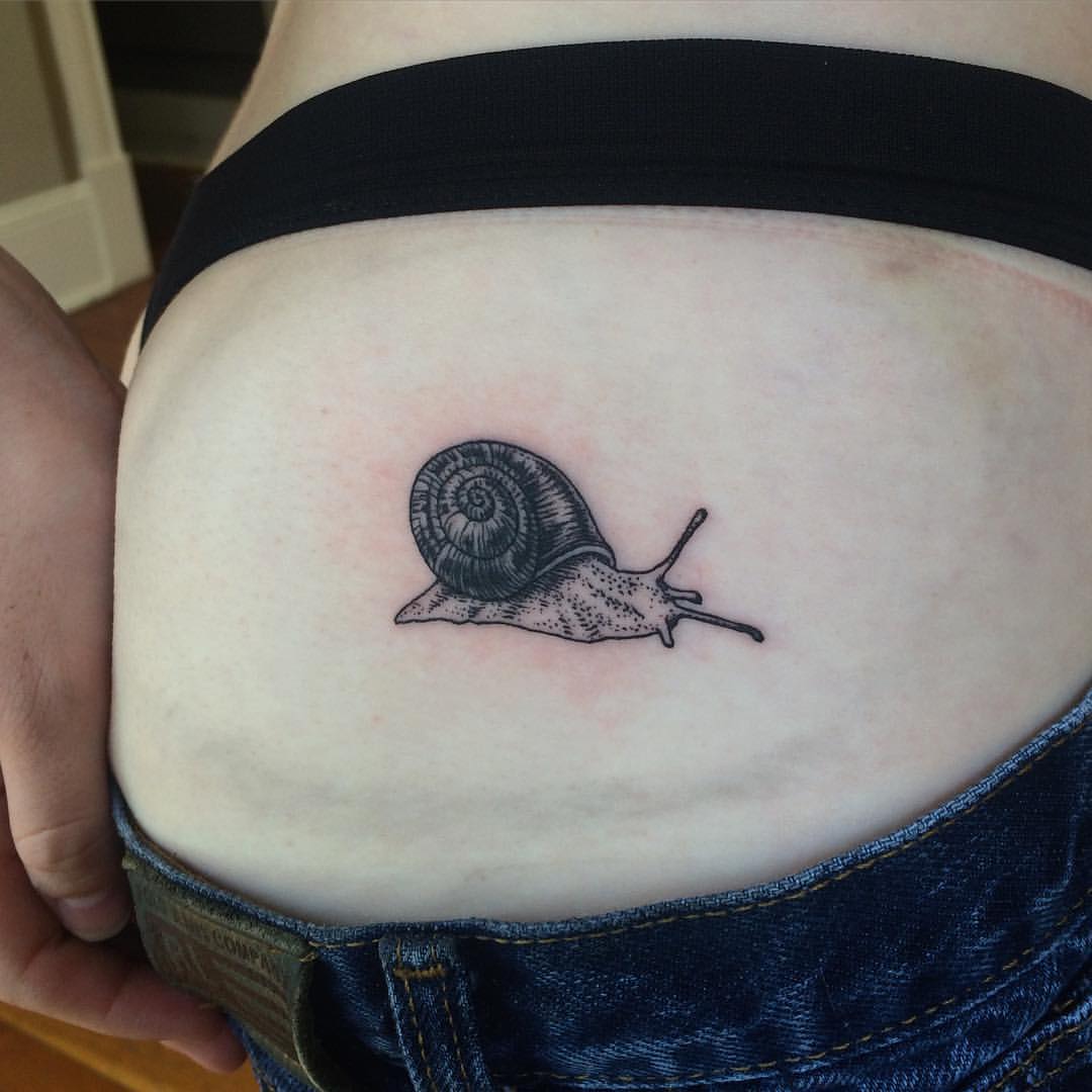 Small Grey Ink Snail Tattoo On Lower Back