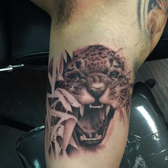 Wonderful Angry Jaguar Head With Leaves Tattoo On Bicep
