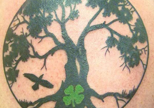 Amazing Black Tree With Crow And Four Leaf Shamrock In Circle Tattoo