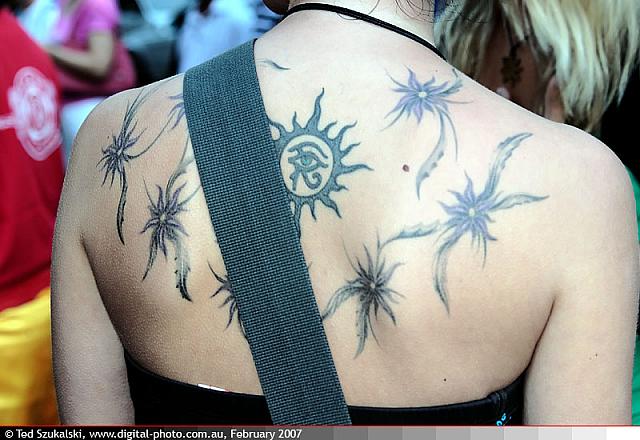 Beautiful Horus Eye In Sun With Flowers Tattoo On Upper Back