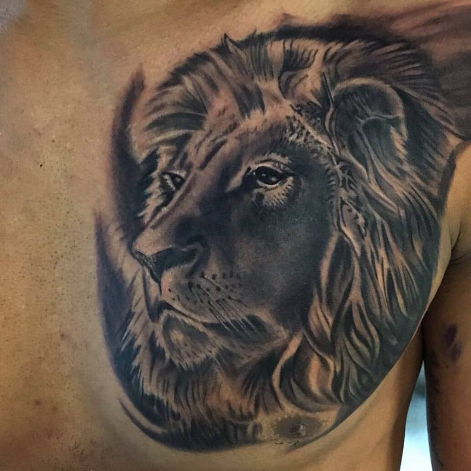 Black And Grey Lion Head Tattoo On Man Chest