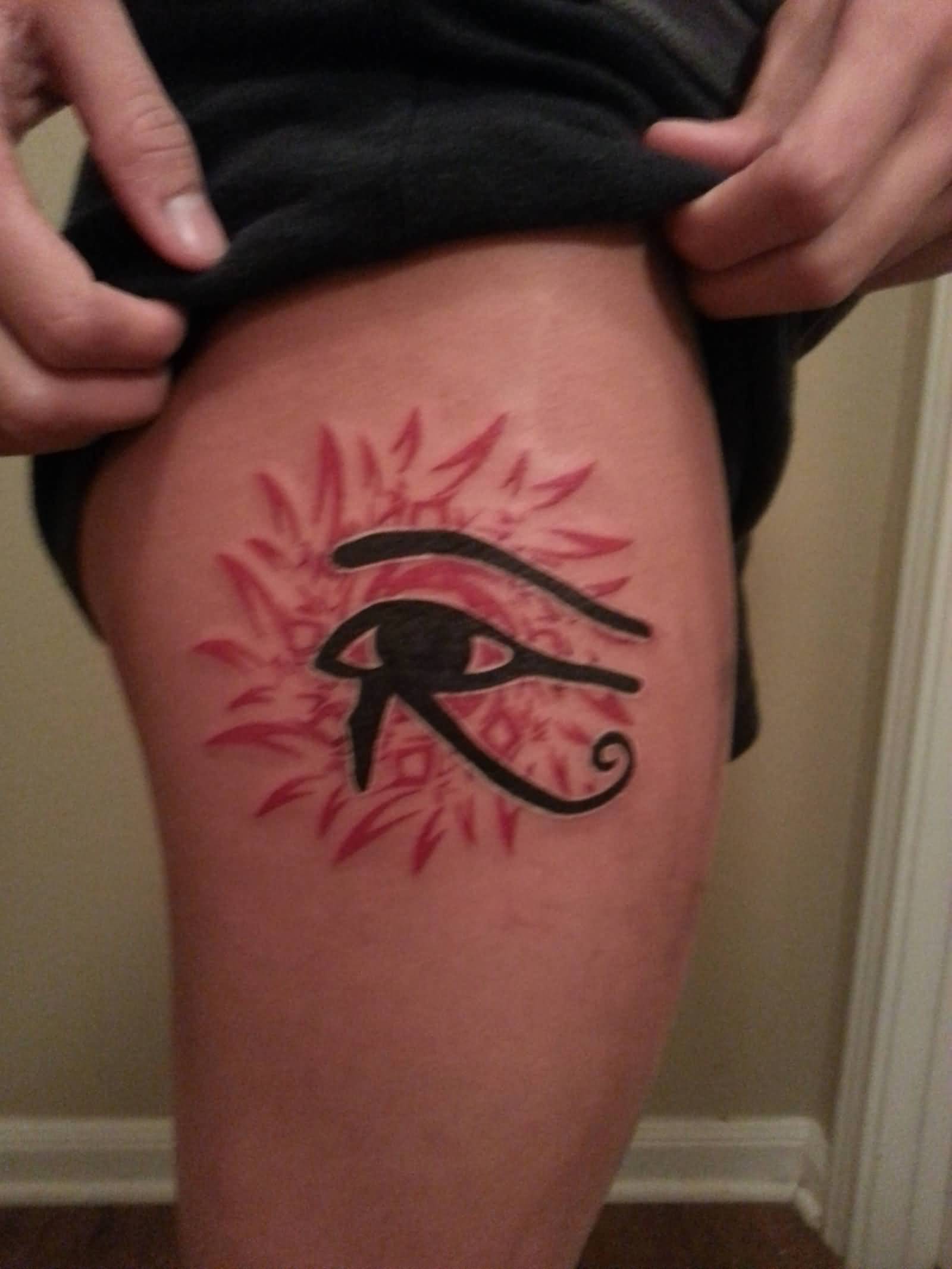 Dark Ink Horus Eye With Red Flower In Background Tattoo On Thigh