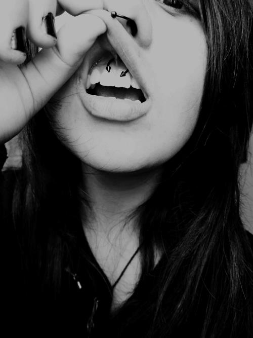 Girl Showing Her Frenulum Piercing With Black Spike Circular Barbell