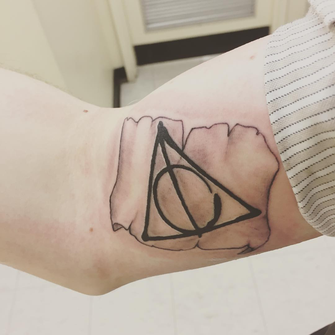 Grey Ink 3D Deathly Hallows On Page Tattoo On Bicep