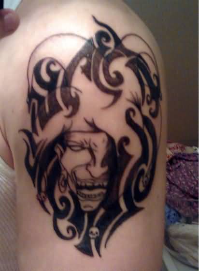 Grey Ink Evil Jester And Tribal Design Tattoo On Left Shoulder