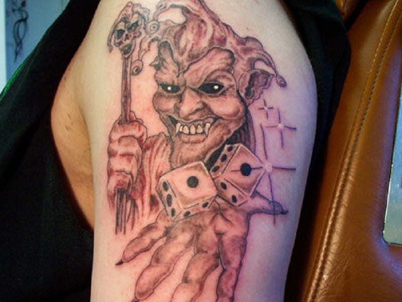 Grey Ink Evil Jester With Dice On Hands Tattoo On Left Half Sleeve