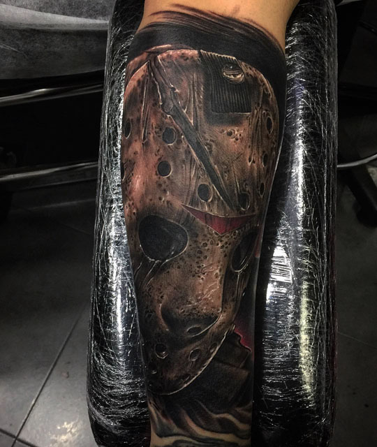 Grey Ink Jason Mask Tattoo On Forearm