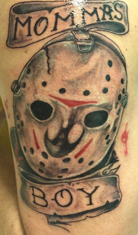 Grey Ink Jason Mask With Lettering On Banner Tattoo