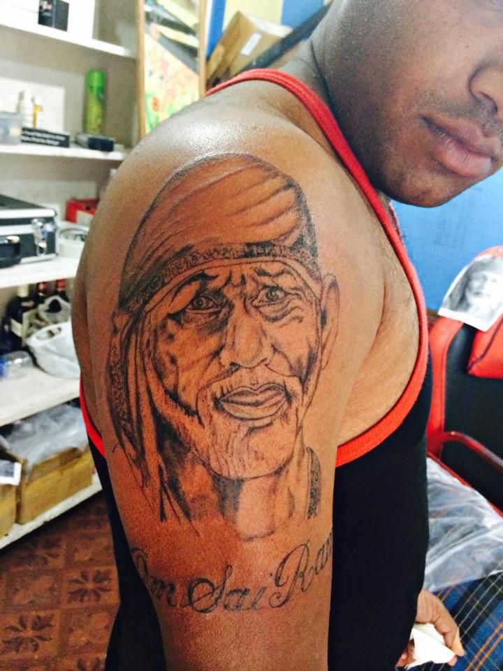Large Sai Baba Face With Lettering Tattoo On Right Shoulder