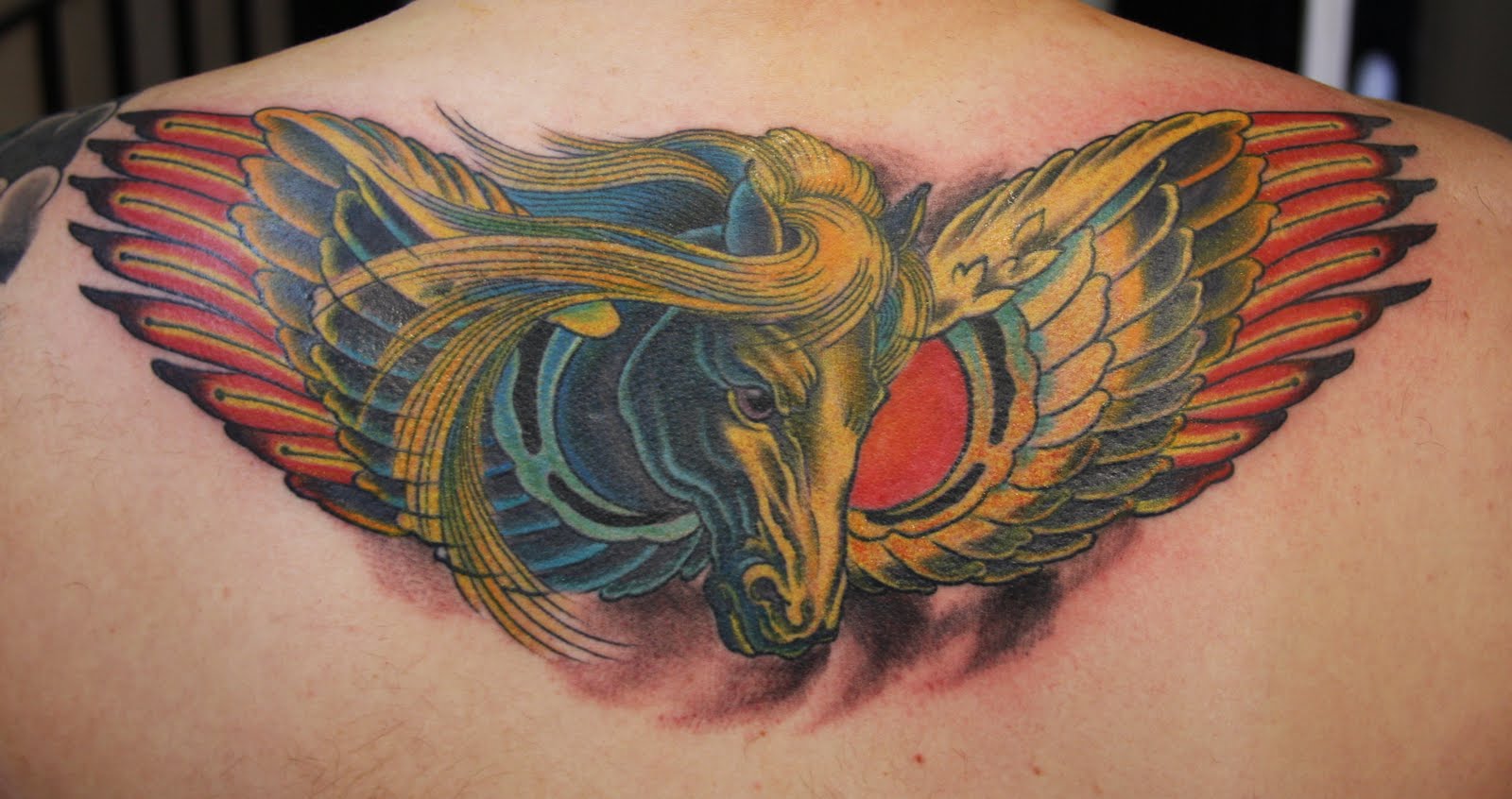 Lovely Colorful Pegasus Head With Wings Tattoo On Upper Back