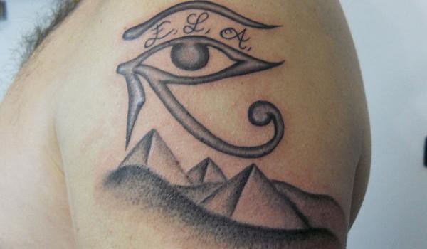 Lovely Grey Horus Eye With Pyramids Tattoo On Left Shoulder