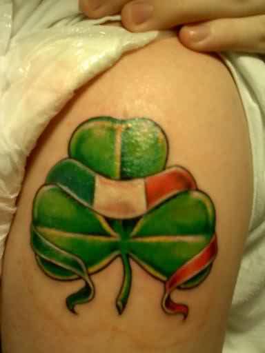 Nice Ireland Flag Banner On Shamrock Leaf Tattoo