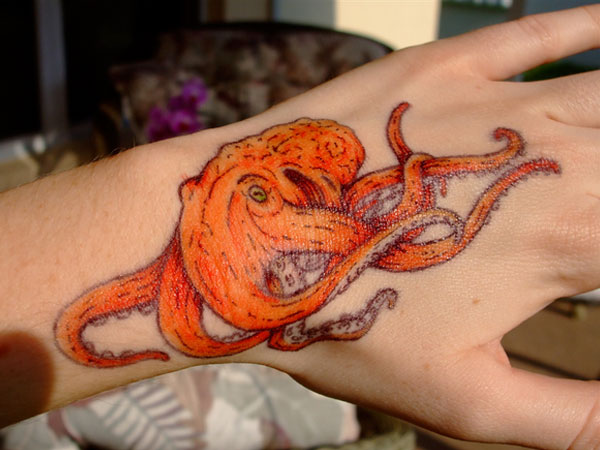 Nice Orange Octopus Tattoo On Hand