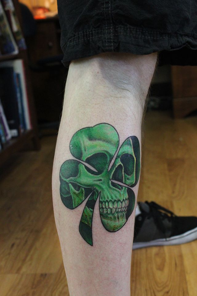 Realistic Skull In Shamrock Leaf Tattoo On Leg