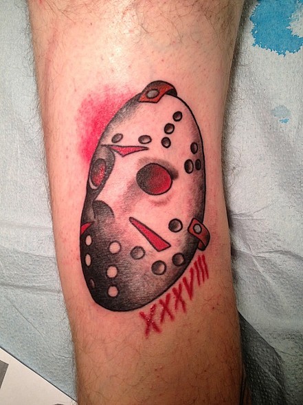 Red And Grey Color Jason Mask With Roman Numerals Tattoo