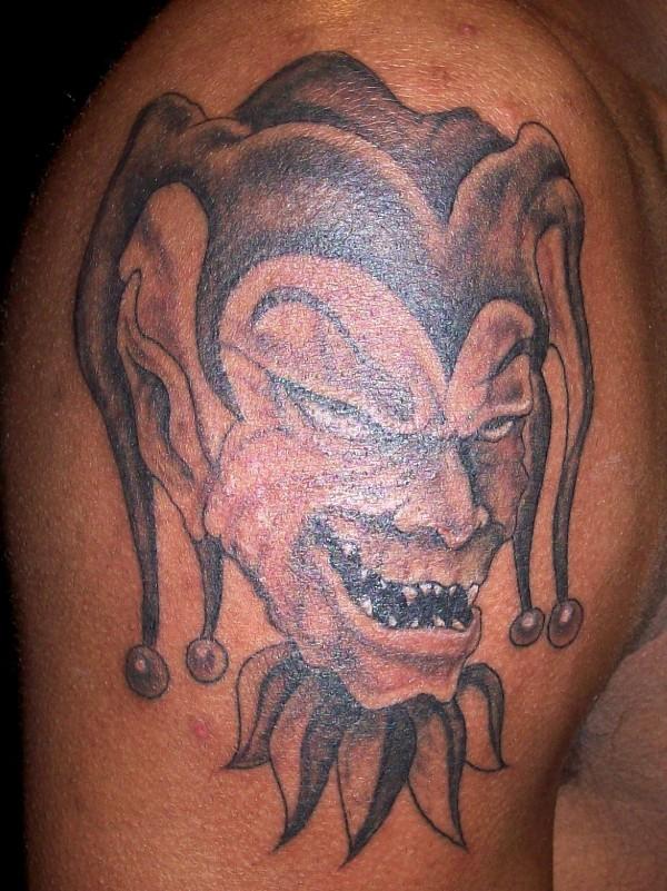 Scary Black And Grey Evil Jester Face Tattoo On Right Shoulder