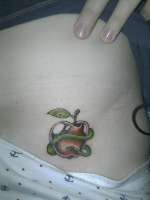 Small Green Worm In Rotten Apple Tattoo On Side Rib