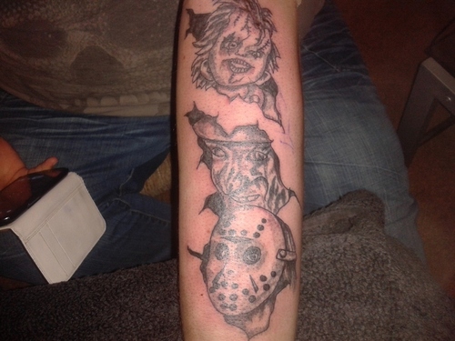 Small Grey Ink Freddy Jason And Chucky Heads Tattoo