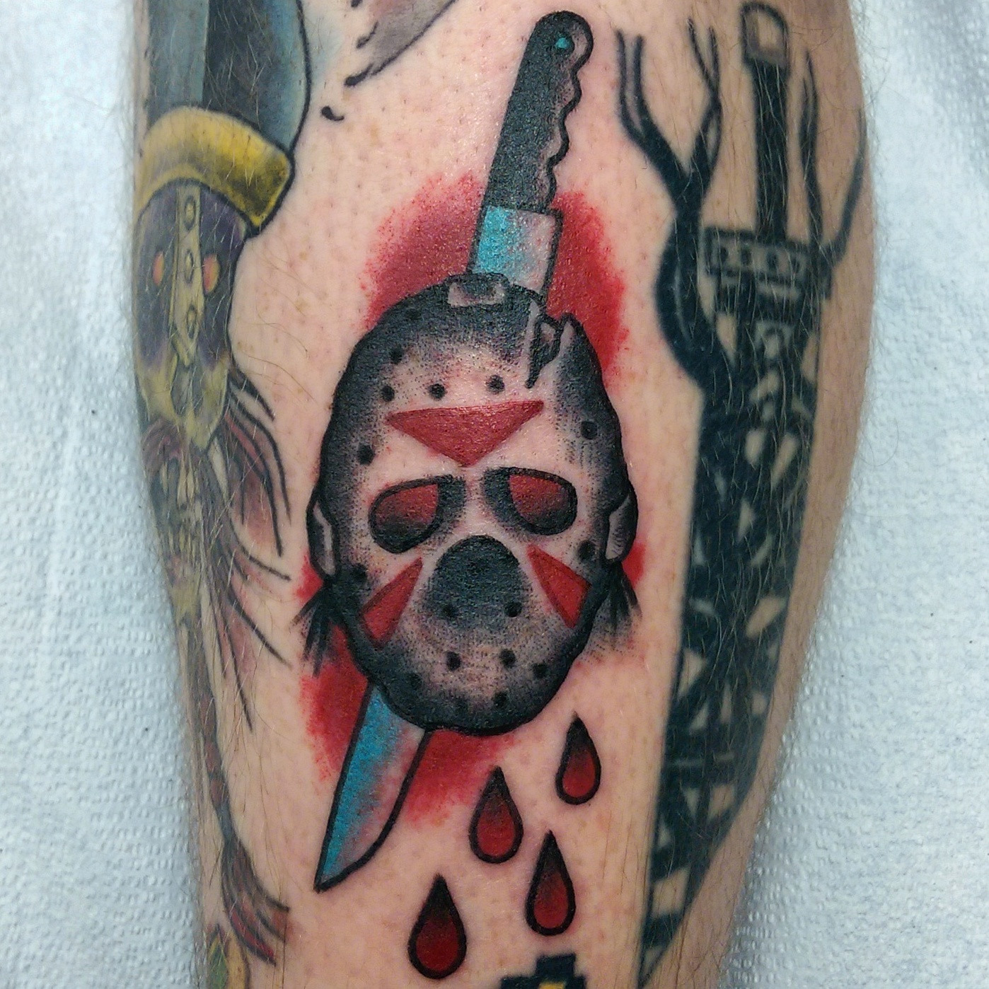 Small Knife Ripped Jason Mask Traditional Tattoo By Scott Kingan