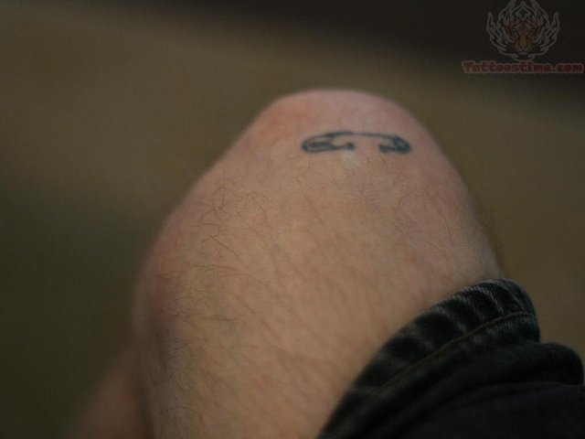Small Safety Pin Tattoo On Leg
