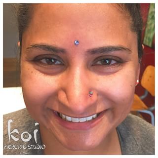 Smiling Girl With Nostril And Third Eye Piercing Picture