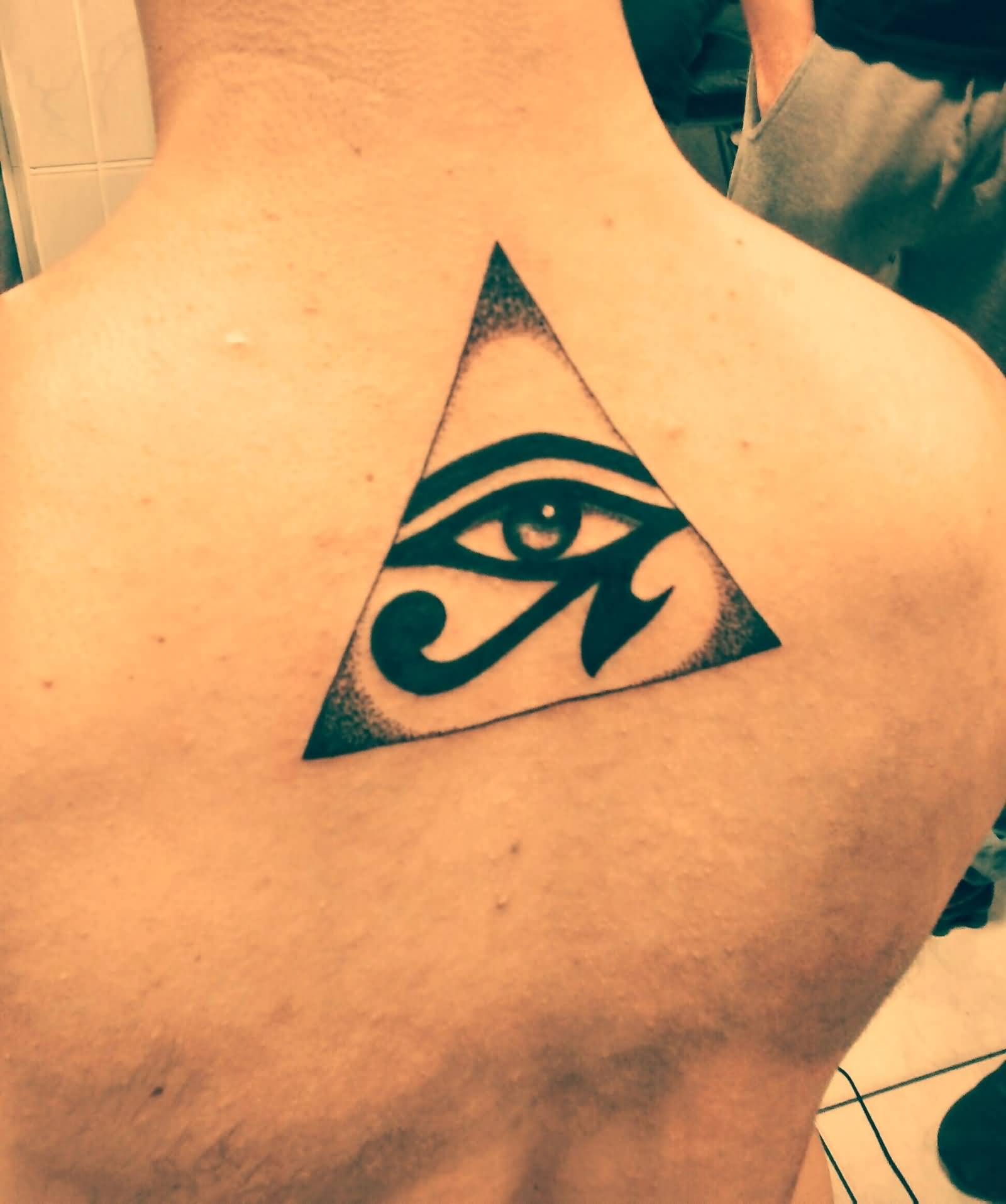 Superb Grey And Black Horus Eye In Pyramid Tattoo On Upper Back