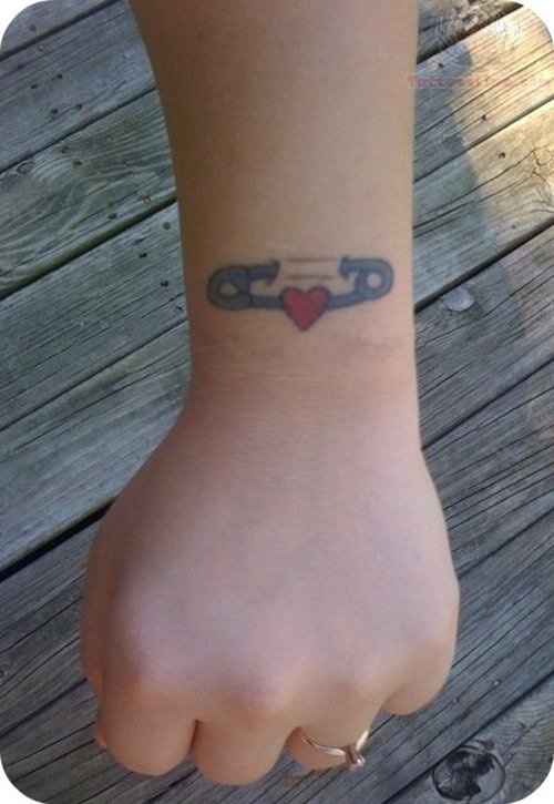 Tiny Red Heart And Safety Pin Tattoo On Wrist