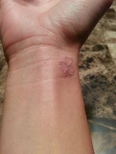 White Ink Shamrock Outline Tattoo On Wrist
