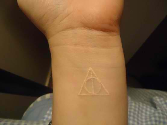 White Ink Simple Deathly Hallows Symbol Tattoo On Wrist