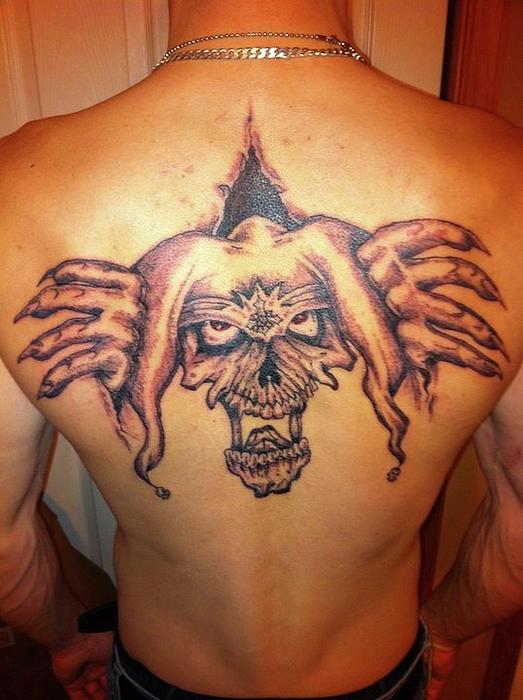 Wonderful Grey Ink Evil Jester Ripped Skin Tattoo On Upper Back
