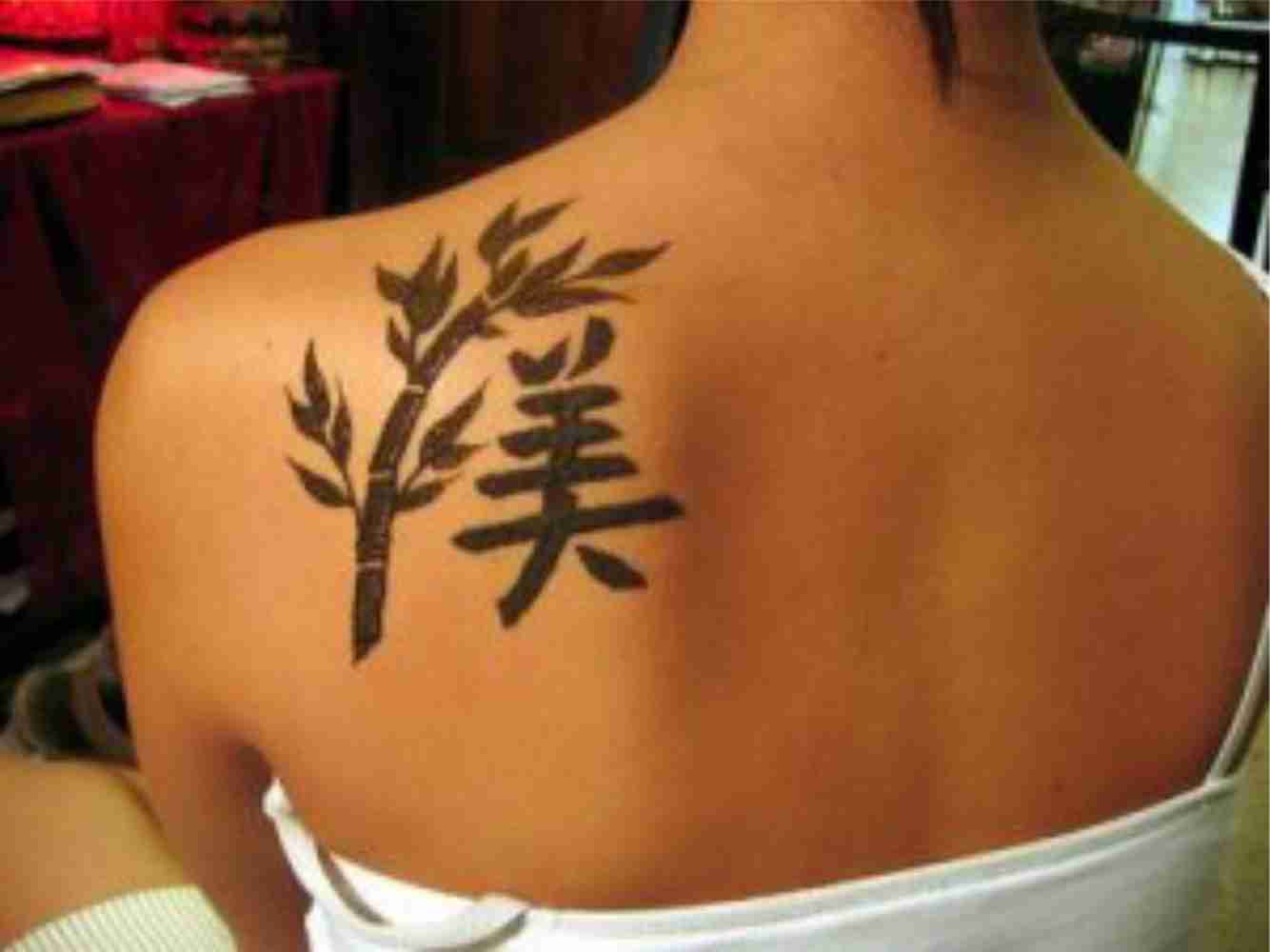 Black Chinese Symbol And Plant Tattoo On Left Back Shoulder