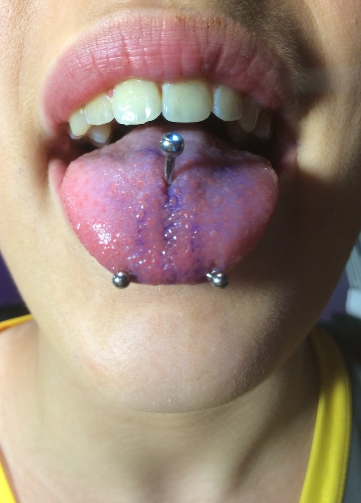 Girl Showing Her Tongue Piercing And Snake Eyes Piercing