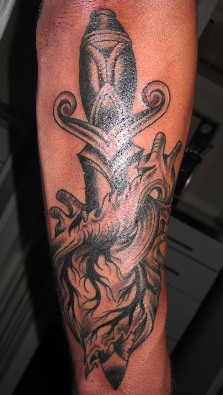 Grey And Black Dagger And Heart Tattoo On Arm