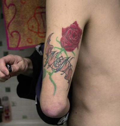 Nice Rose Flower With Mom Banner Tattoo On Triceps