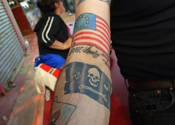 Pirate Flag With American Flag Tattoo On Sleeve