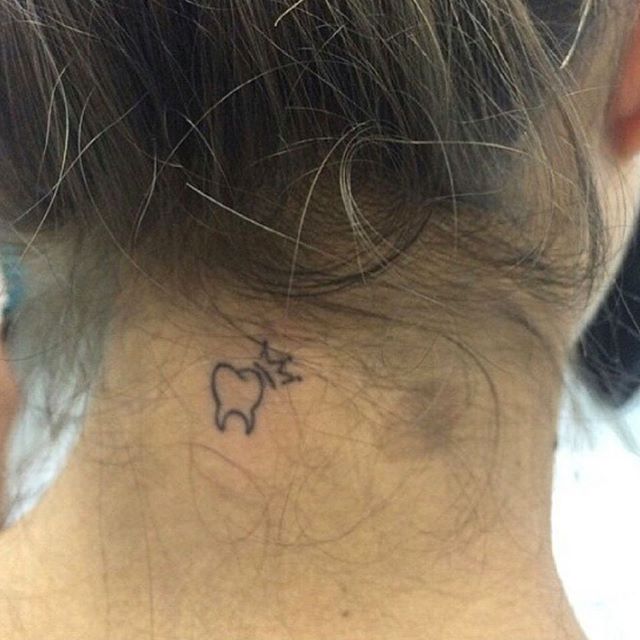 Tiny Molar With Crown Tattoo On Nape