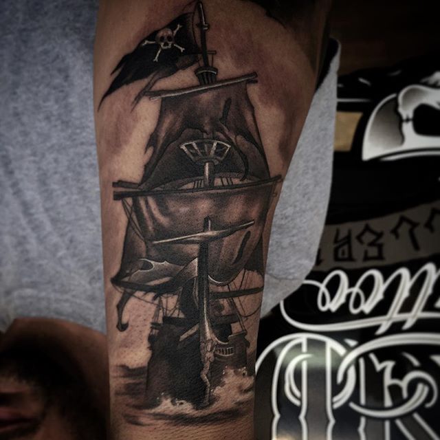Black And Grey Ink Pirate Ship Tattoo On Arm