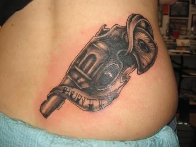 Black Ink Banner And Gun Weapons Tattoo On Lower Back